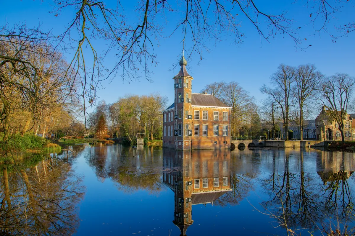 Kasteel Bouvigne in Breda, weerspiegeld in de slotgracht op een heldere herfstdag