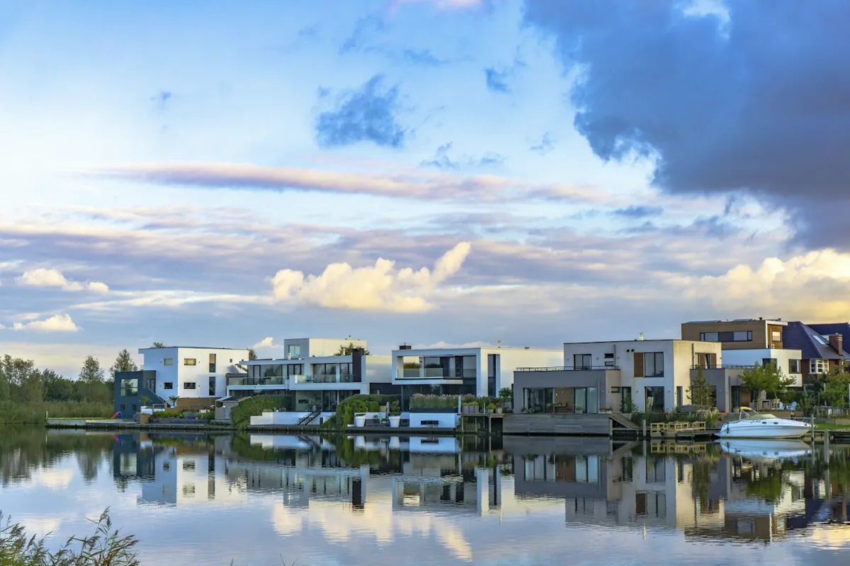 Moderne vrijstaande woningen aan het water in Almere, weerspiegeld in het meer