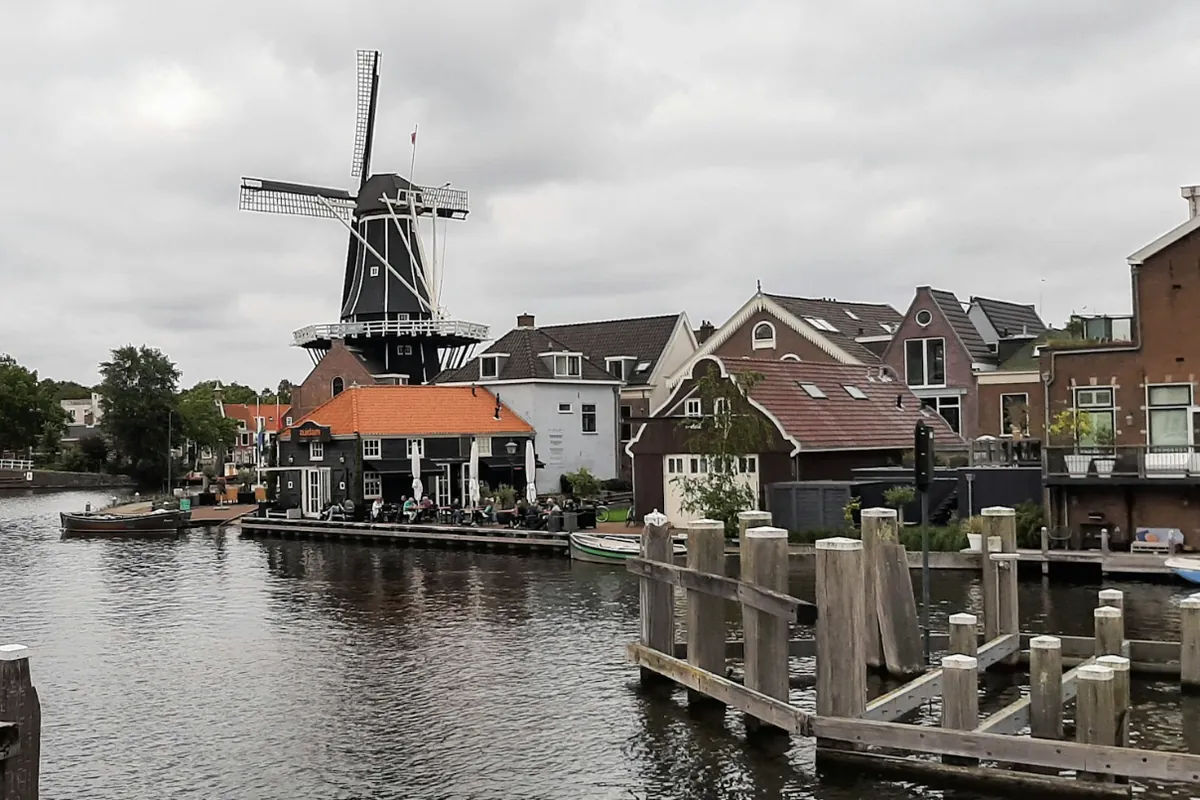 Molen De Adriaan aan het Spaarne in Haarlem met woningen langs het water