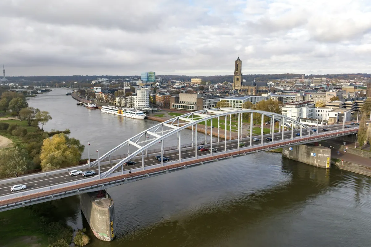 De Rijn bij Arnhem met een boogbrug en de binnenstad met de Eusebiuskerk