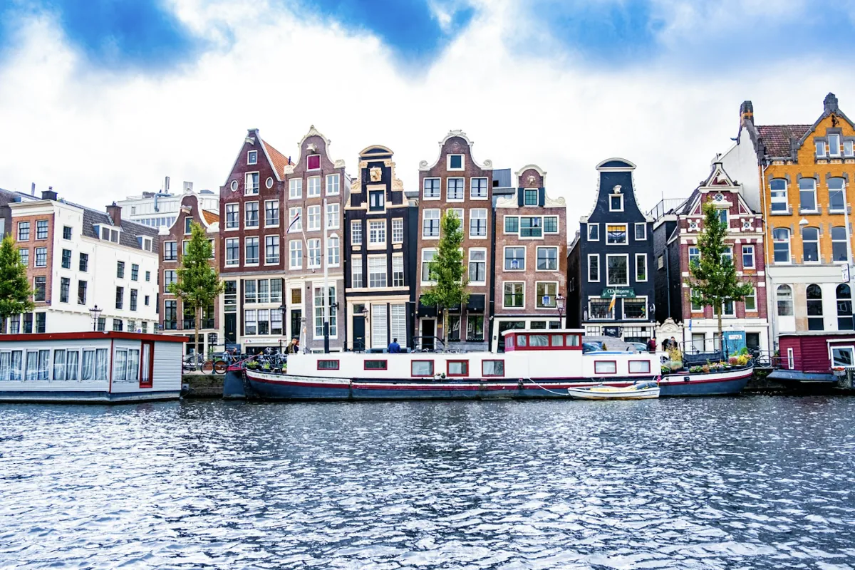 Woonboten voor smalle grachtenpanden met trapgevels aan het water in Amsterdam